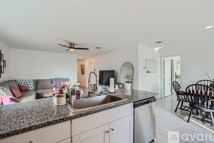A kitchen with granite countertops and a dining area with a table and chairs.