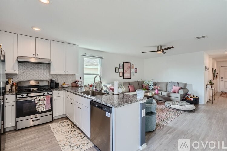 A modern kitchen with a large island and a dining area.