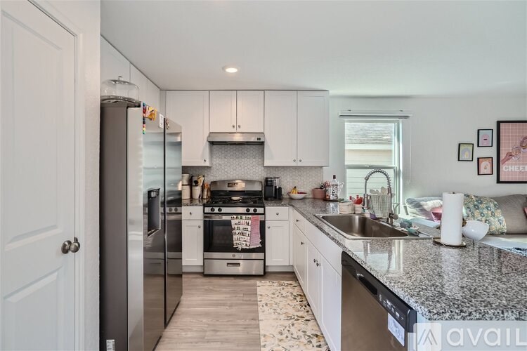 A kitchen with a granite countertop and stainless steel appliances.