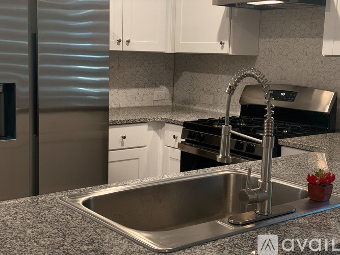 A modern kitchen with a stainless steel sink and black appliances.