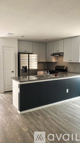 A kitchen with a black countertop and white cabinets.