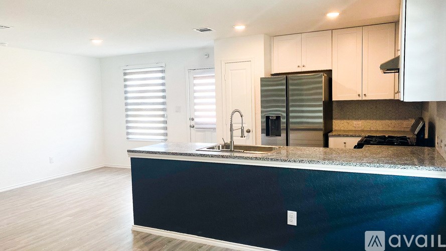 A kitchen with a black countertop and white cabinets.