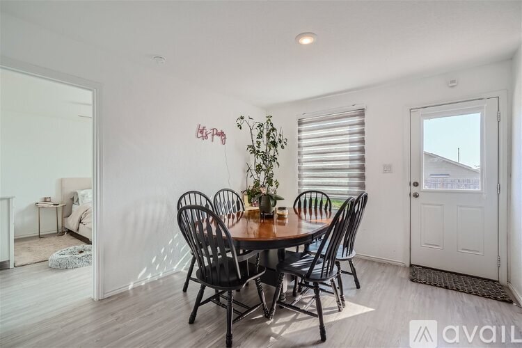 A dining room with a table and chairs.