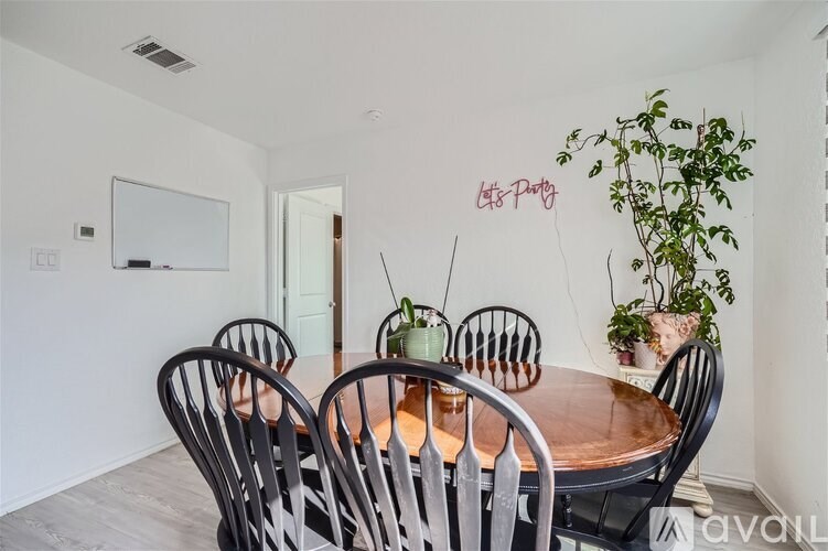 A dining room with a wooden table and chairs.