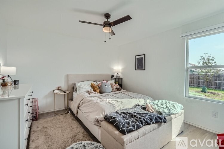 A bedroom with a large bed and a ceiling fan.