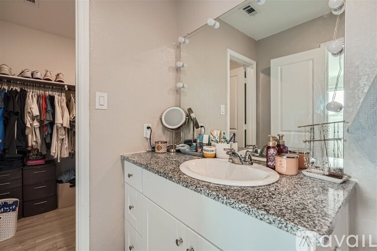 A bathroom with a marble countertop and a double sink.