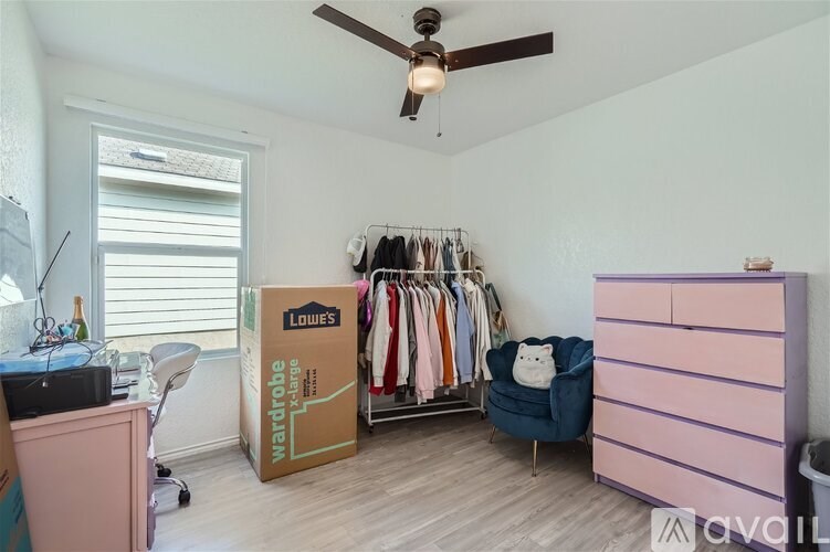 A room with a clothing rack and a blue chair.