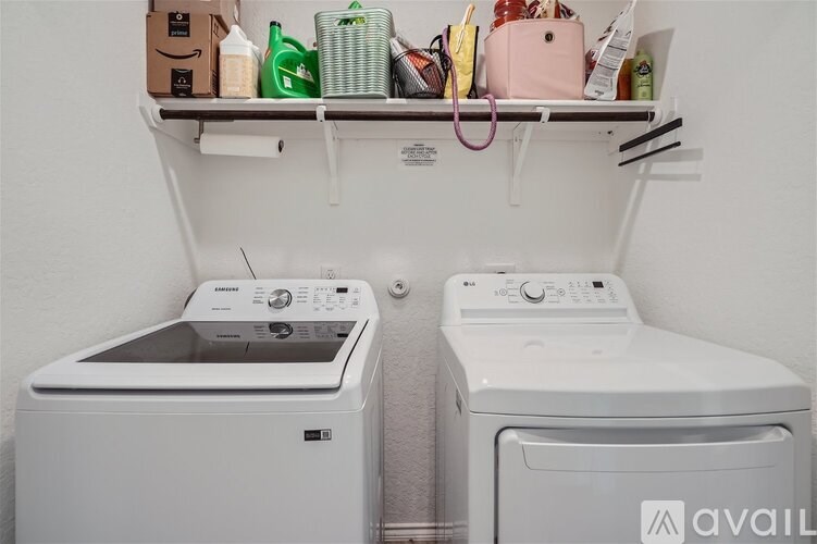 Two white front loading washing machines in a small laundry room.