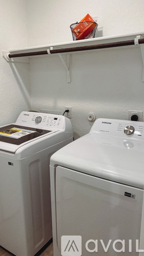 A small room with two washing machines, one of which is a Samsung.