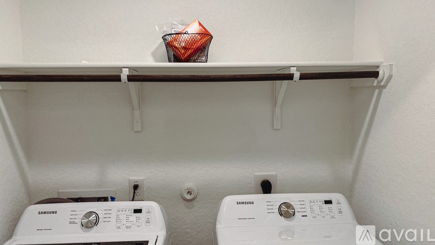 Two Samsung washing machines are sitting on a shelf.