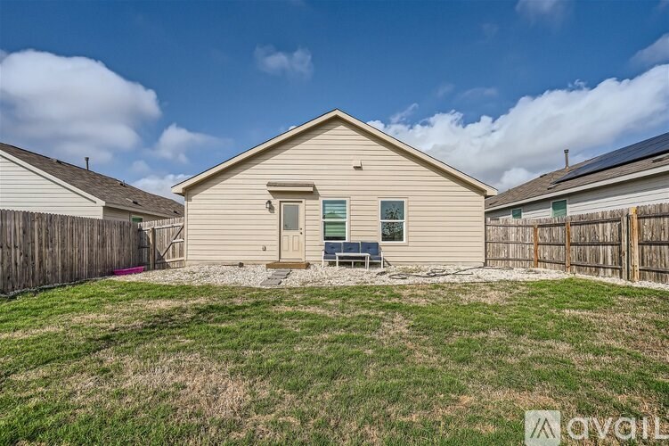 A beige house with a brown fence and a small garden in front.