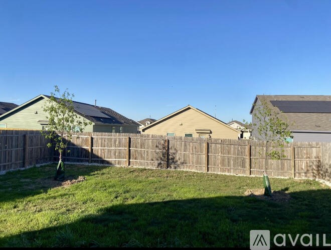 A sunny day in a residential area with houses and fences.