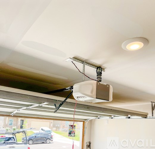 A garage door opener is hanging from the ceiling.