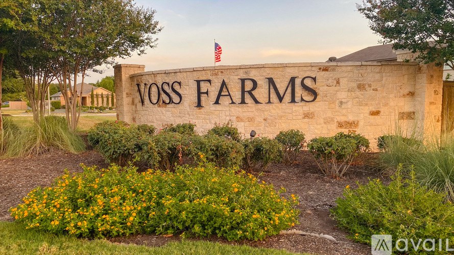 Voss Farms sign with flowers in front and an American flag on top.
