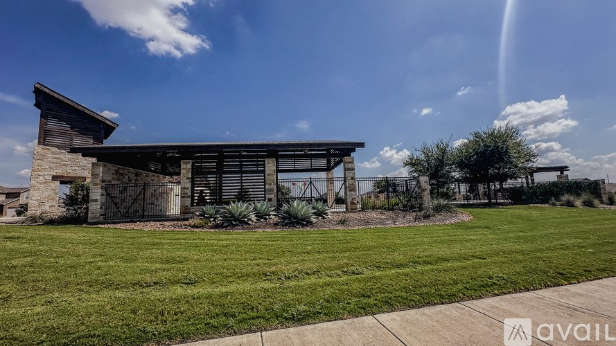 A modern house with a stone facade and a large front yard.
