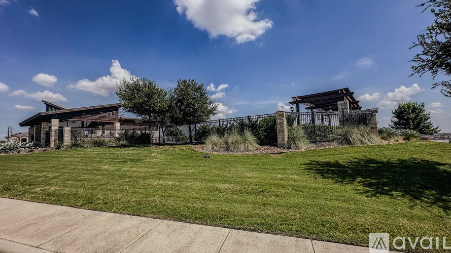 A house with a fence and a tree in front of it.