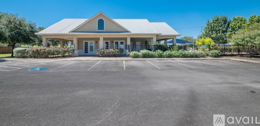A small building with a white roof and a parking lot in front.