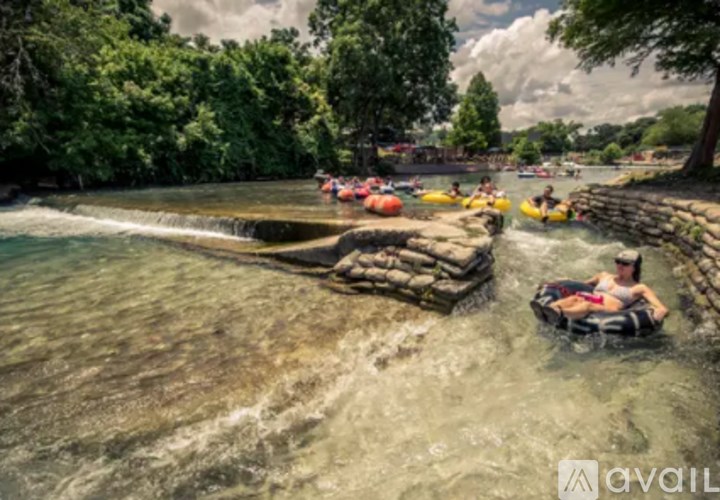 People are rafting down a river with rocks on the side.