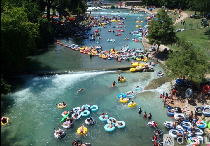 A group of people are floating down a river on inner tubes.