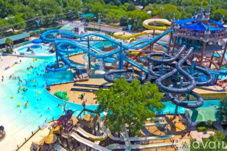 A water park with a large blue water slide and people enjoying the water.