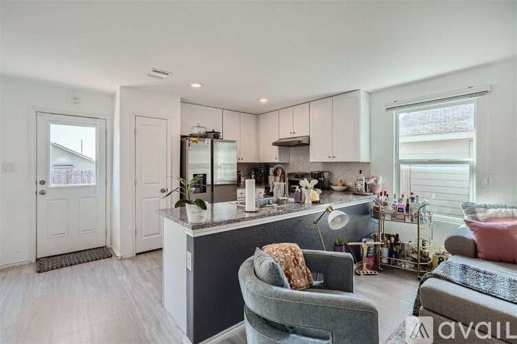 A kitchen with a grey couch and a grey chair.