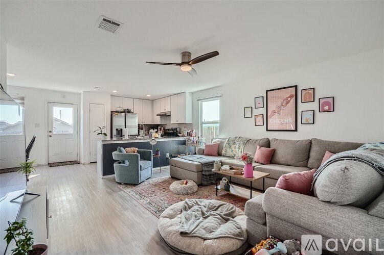 A living room with a grey couch and a ceiling fan.