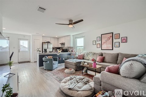 A living room with a grey couch and a ceiling fan.