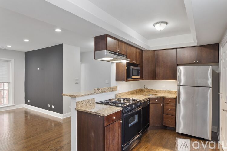 A kitchen with wooden cabinets and a stainless steel refrigerator.
