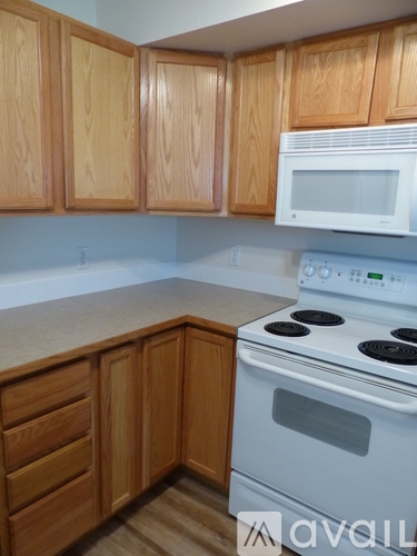 A kitchen with wooden cabinets and a white stove.