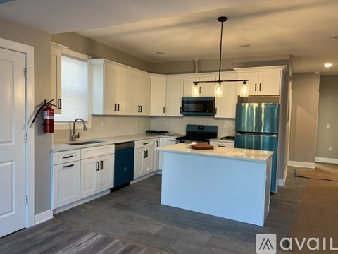 A kitchen with white cabinets and a blue island.