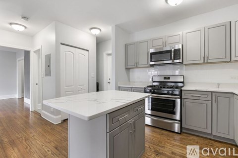 A kitchen with a white countertop and stainless steel appliances.