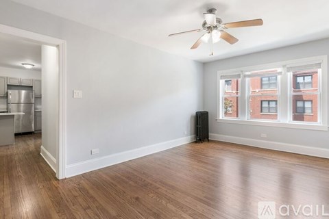A room with a ceiling fan and wooden flooring.