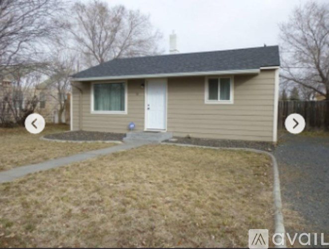 A house with a grey roof and beige siding is for sale.