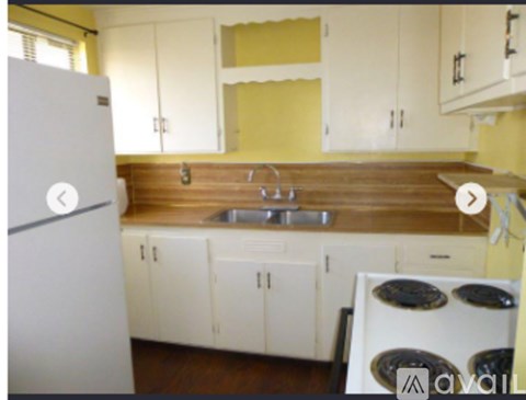 A kitchen with a white refrigerator and a wooden countertop.