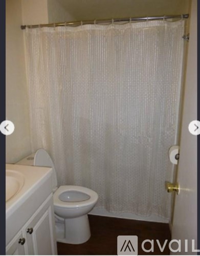 A white toilet sits in a bathroom next to a sink.