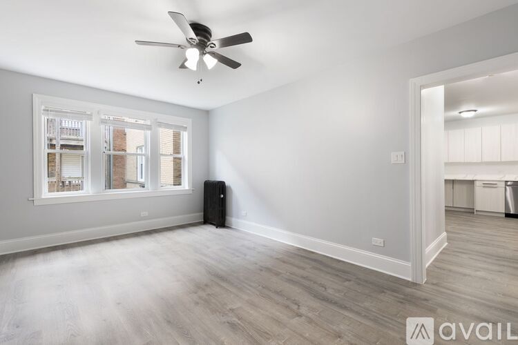 A room with a ceiling fan and a window with blinds.