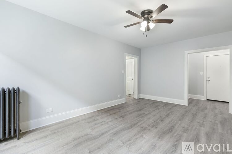 A room with a ceiling fan and a radiator on the floor.