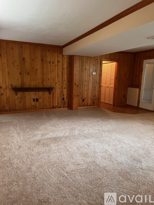 A room with wooden walls and a carpeted floor.