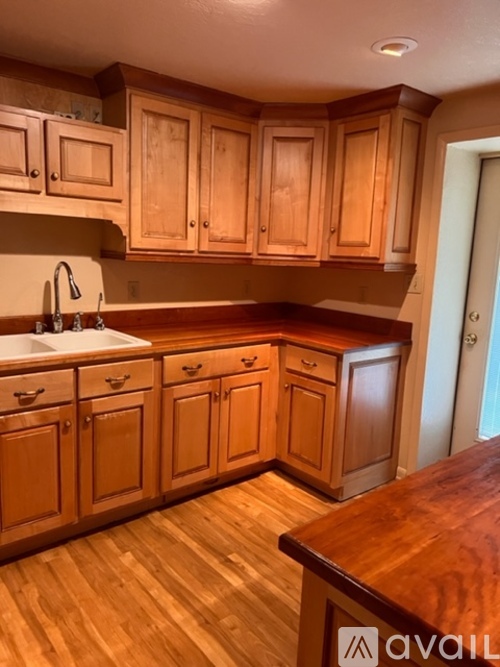 A kitchen with wooden cabinets and a wooden counter top.