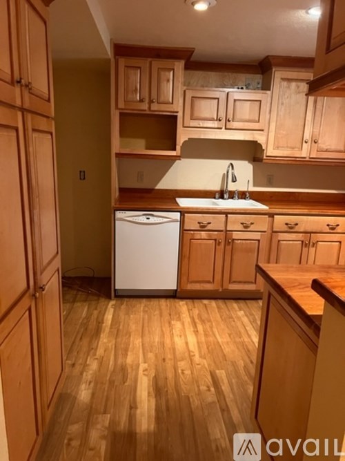 A kitchen with wooden cabinets and a white dishwasher.