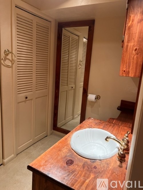 A bathroom with a wooden counter top and a white sink.