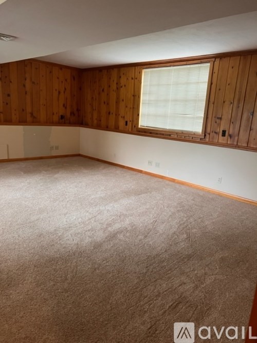 A room with wooden walls and carpeted floor.