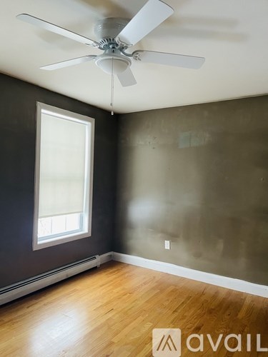 A room with a ceiling fan and a window.
