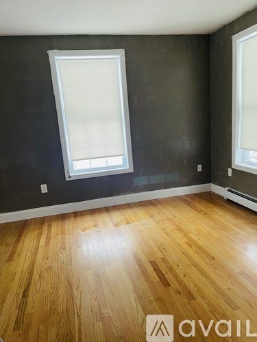 A room with wooden flooring and a window.