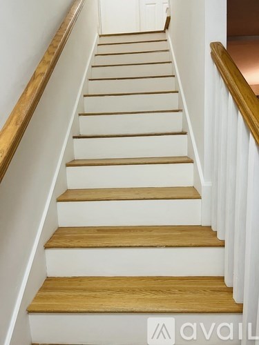 A set of wooden stairs with white risers.