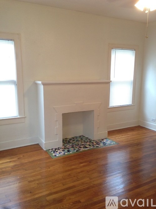 A room with a fireplace and wooden floors.