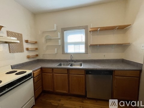 A kitchen with wooden cabinets and a white stove top oven.