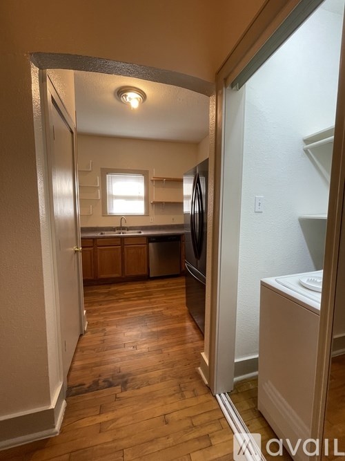 A kitchen with wooden floors and white walls.