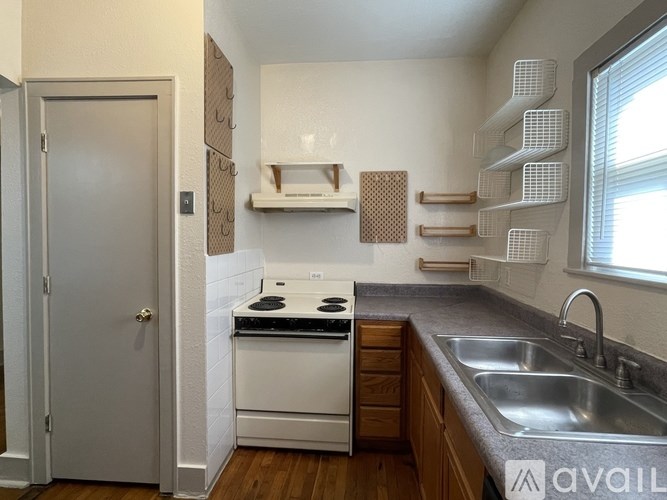 A small kitchen with a white oven and wooden cabinets.