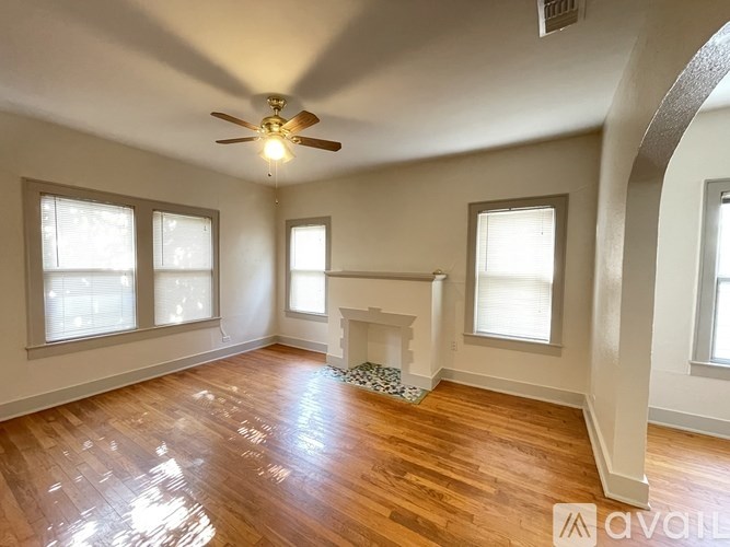 A room with wooden floors and a fireplace is available for rent.